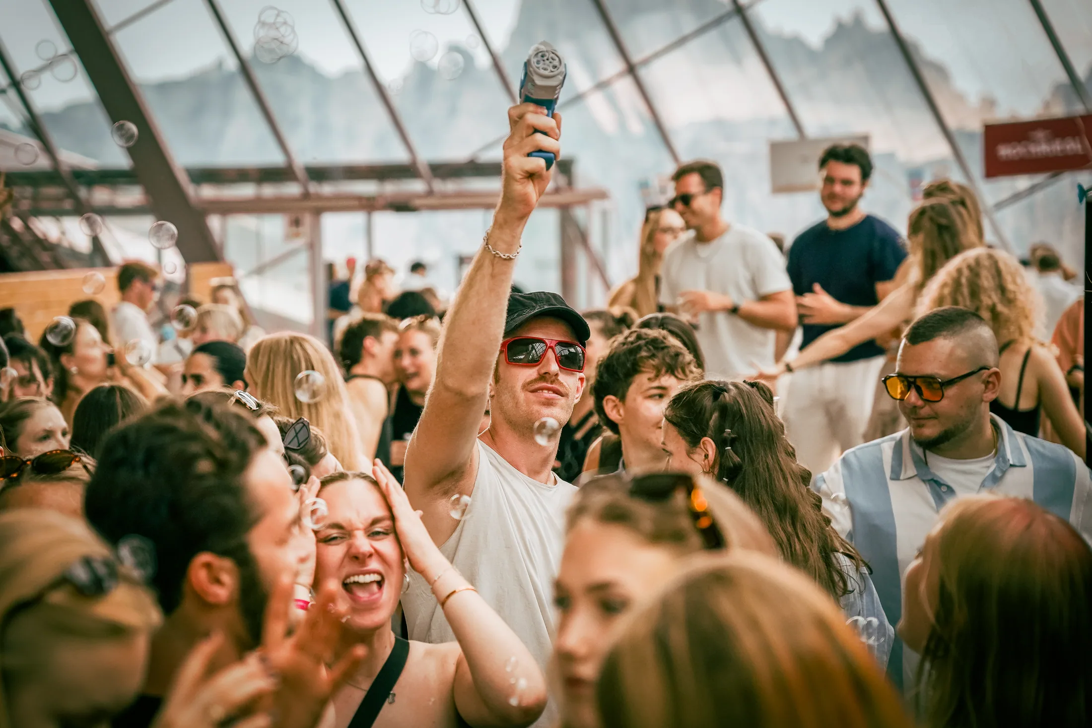 Festival crowd dancing beneath the glass mountain venue