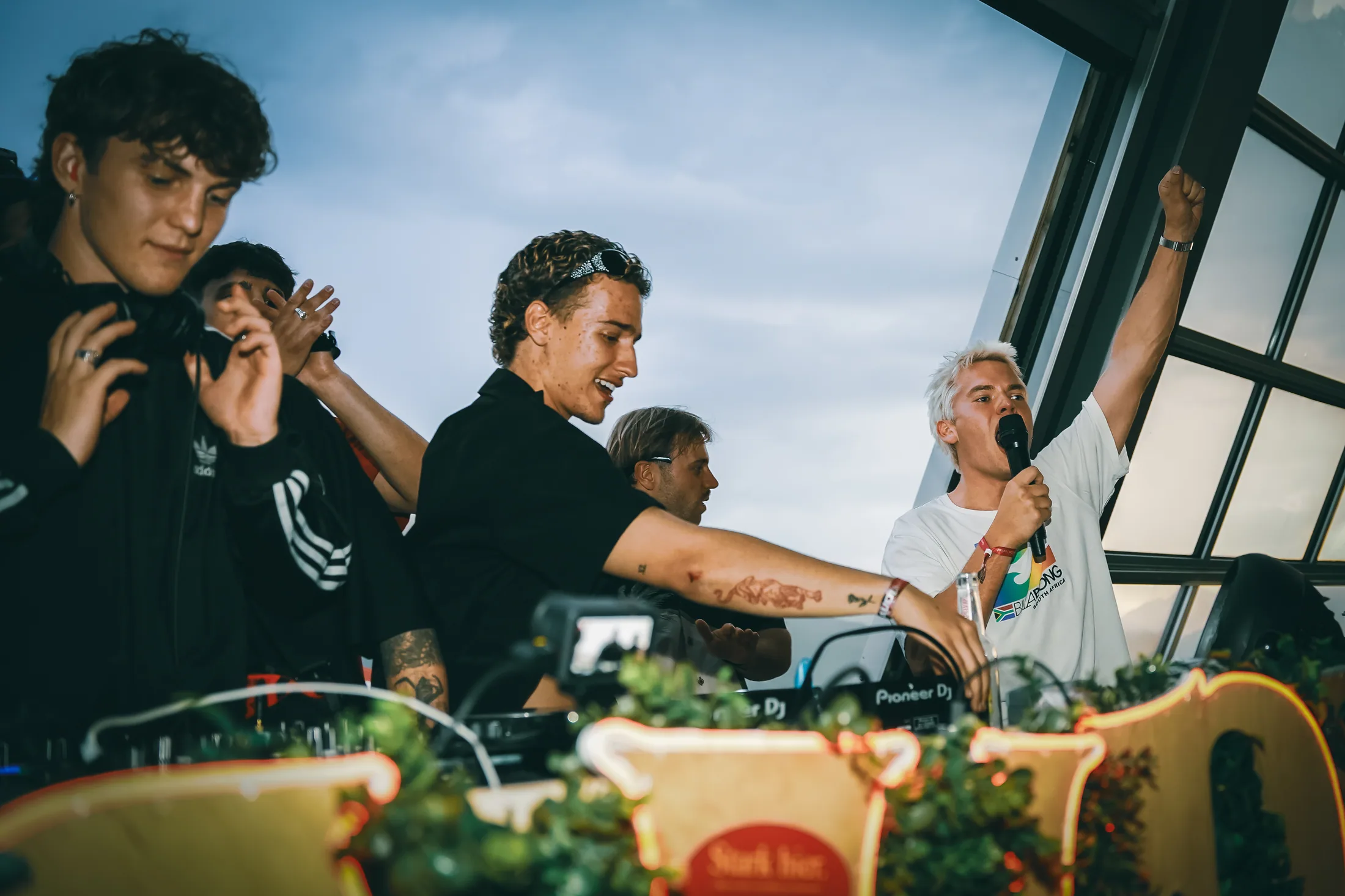 DJs playing a Hoadl set behind the flower-covered booth