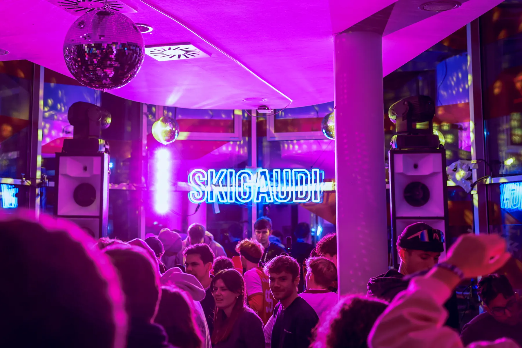 Skigaudi-Clubnacht in pinkem Licht unter einer Discokugel