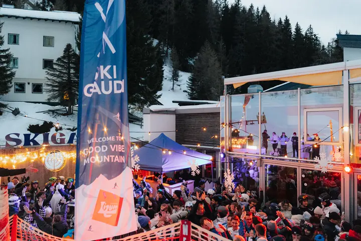 Skigaudi party with a Good Vibe Mountain banner in the snow